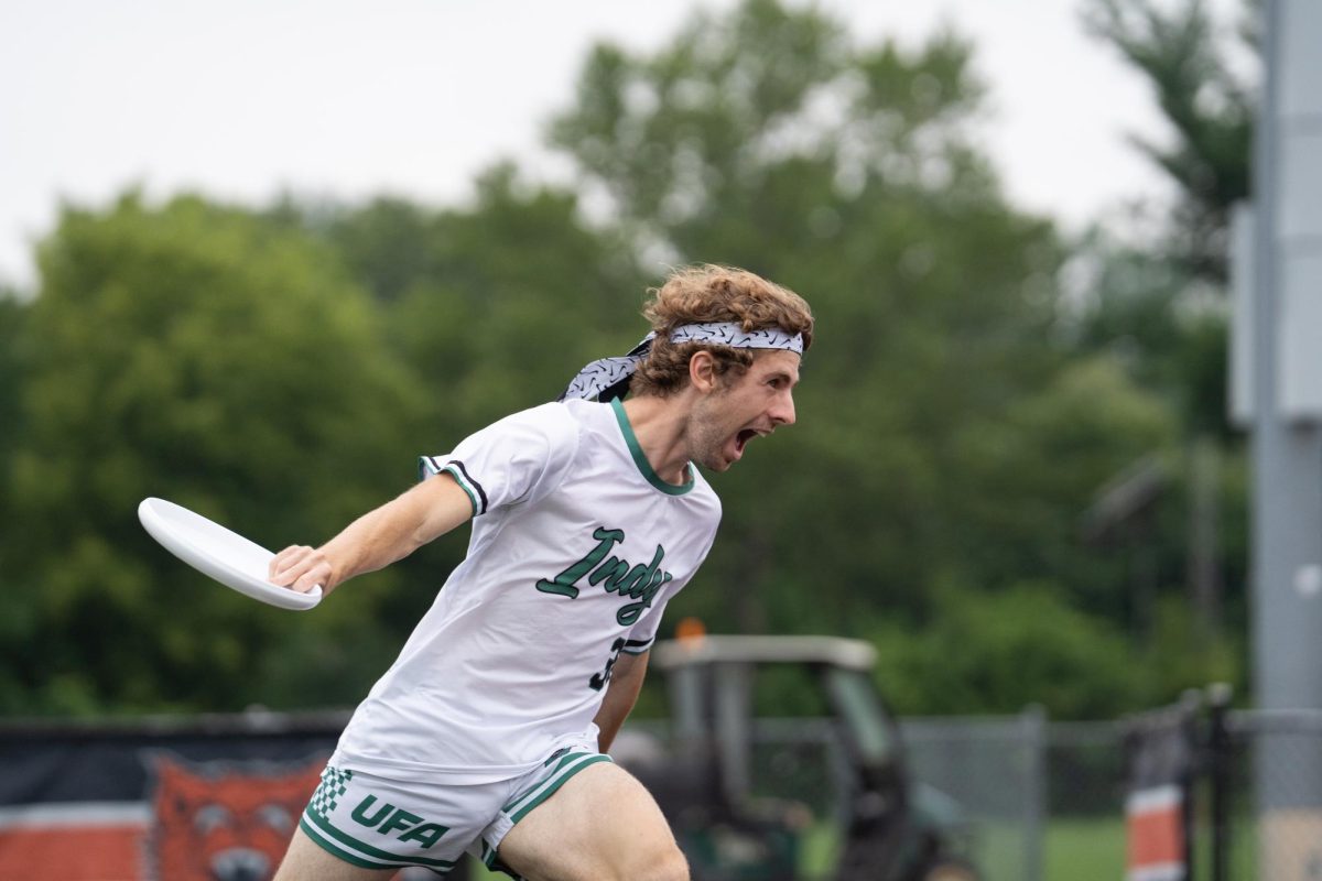 A player in white jumps with a disk after scoring.