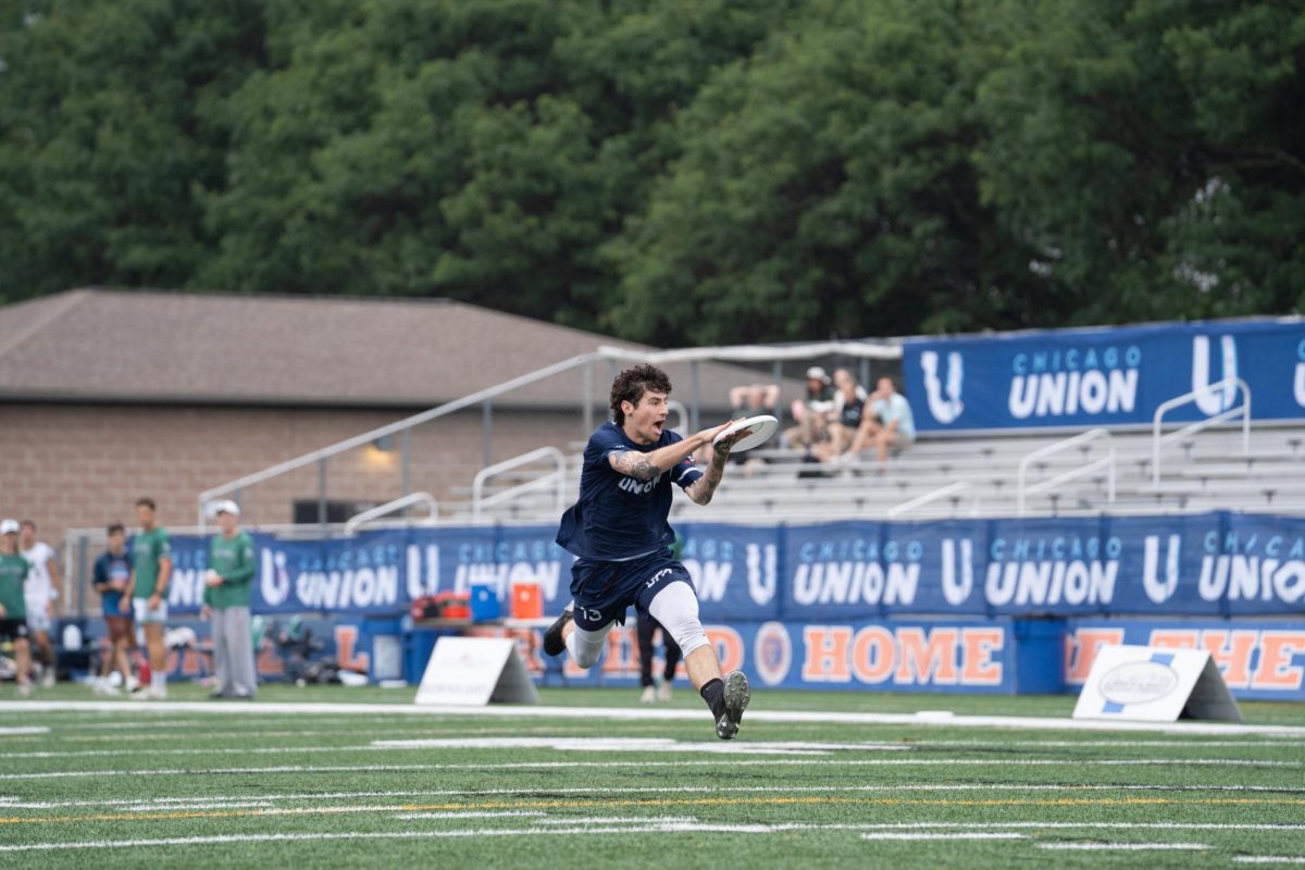 A player in blue catches a disk while lunging forward
