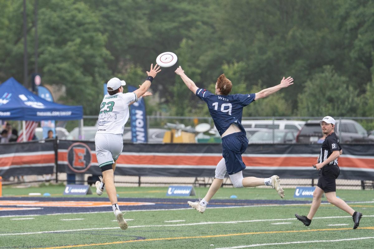 A player in blue and a player in white jump for a disc.