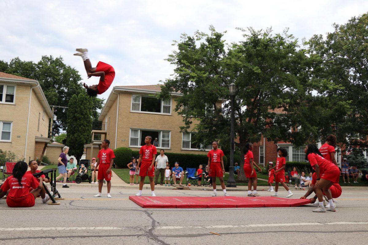 A person flips in the air in front of a crowd