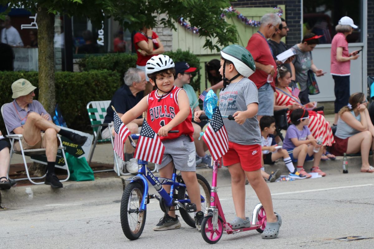 Two children on bikes smile at each other