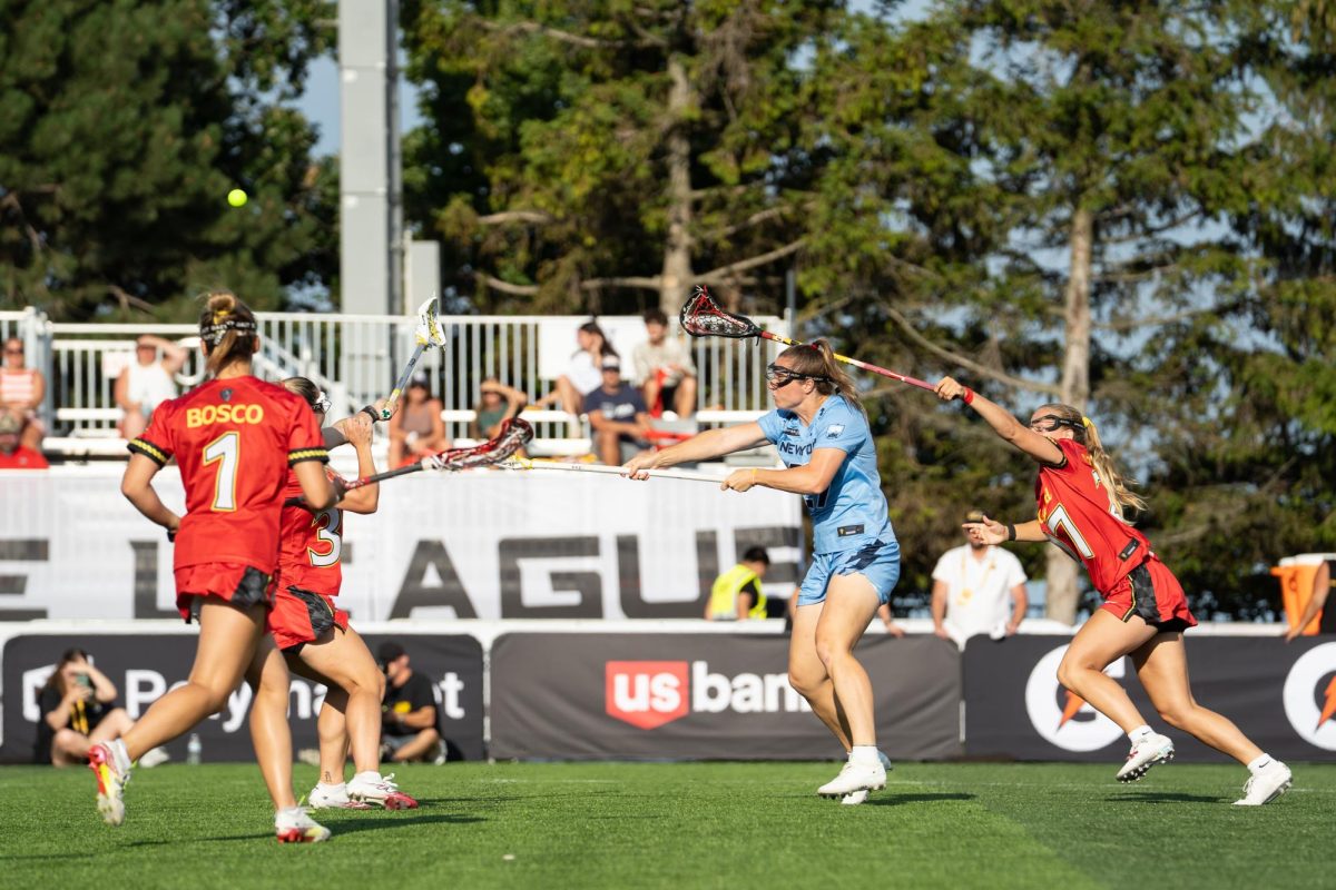 A player in a blue jersey shoots a ball over multiple defenders.